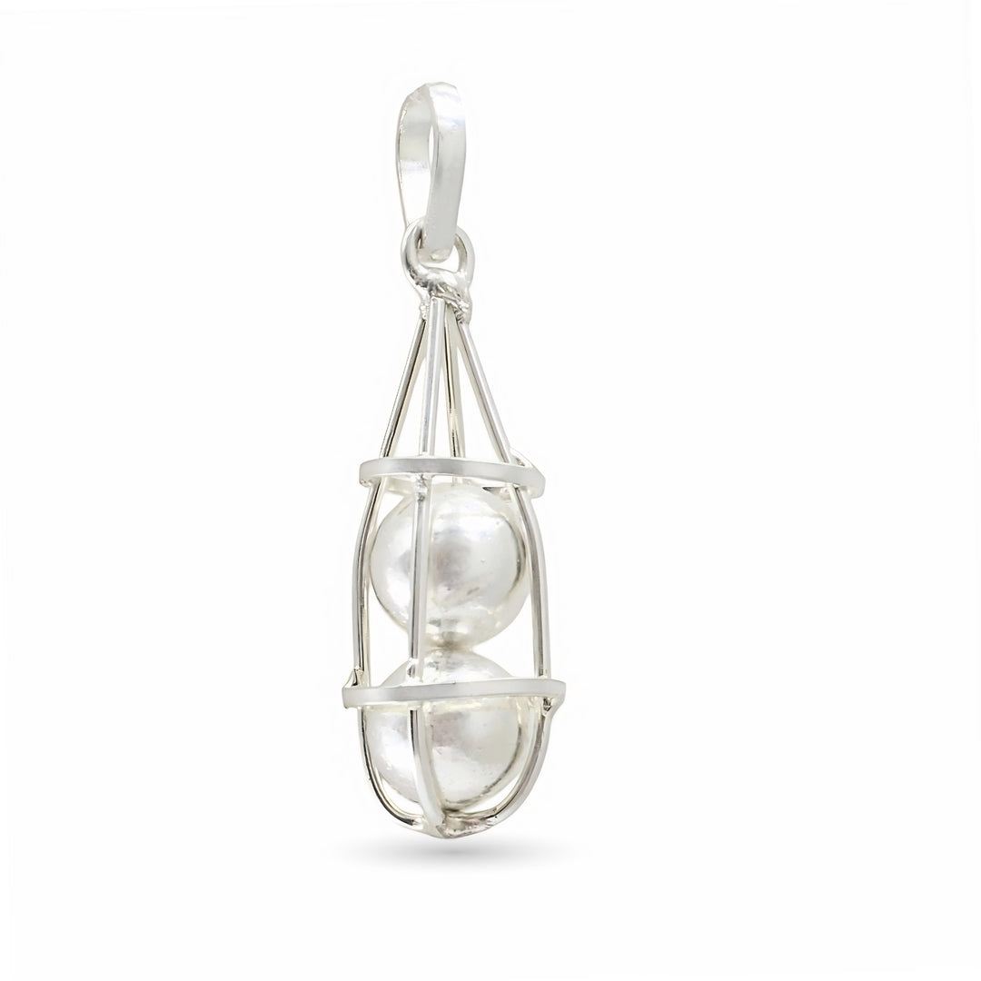 A silver pendant shaped like an open wire cage holding two shiny round silver balls stacked on top of each other.