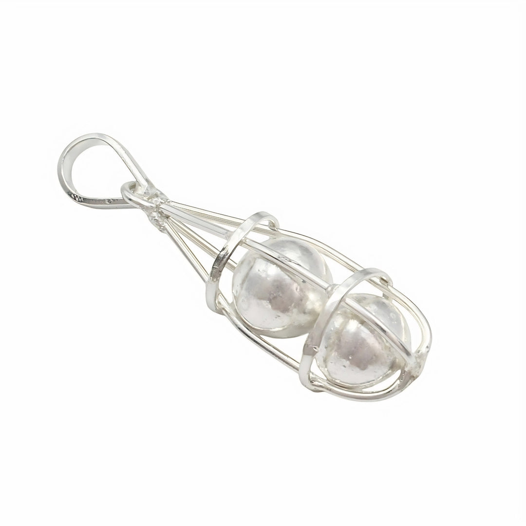 A silver pendant featuring two shiny, round silver balls trapped inside an elongated, open wire cage with a loop at the top for a chain.