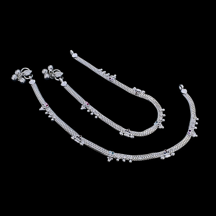 Traditional Indian silver anklet set with delicate chain links, jingle bells, and subtle multi-colored stone accents.