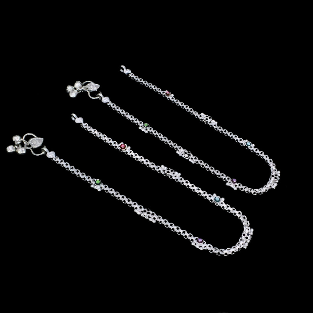 A pair of elegant silver anklets featuring colorful CZ stone accents, delicate floral motifs, and charming ghungroo details for a graceful and traditional look.
