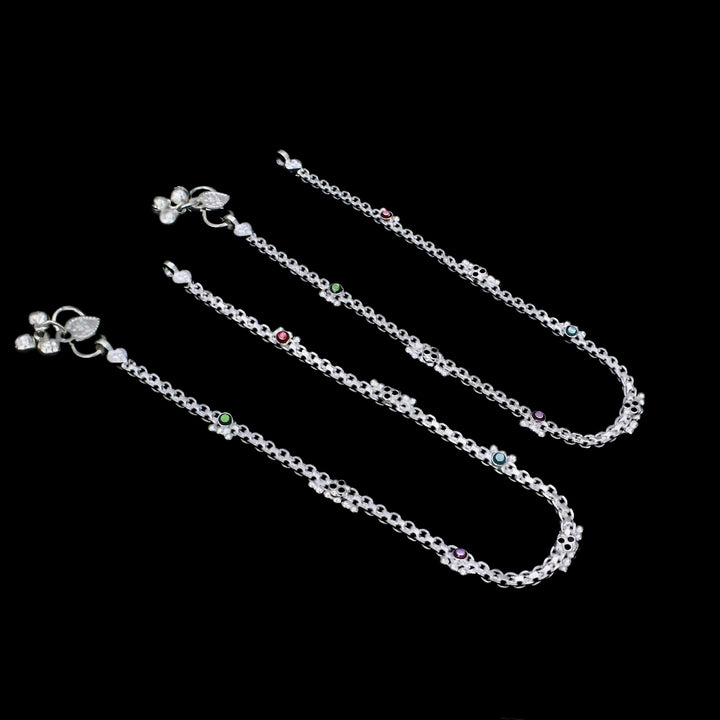 A pair of elegant silver anklets featuring colorful CZ stone accents, delicate floral motifs, and charming ghungroo details for a graceful and traditional look.