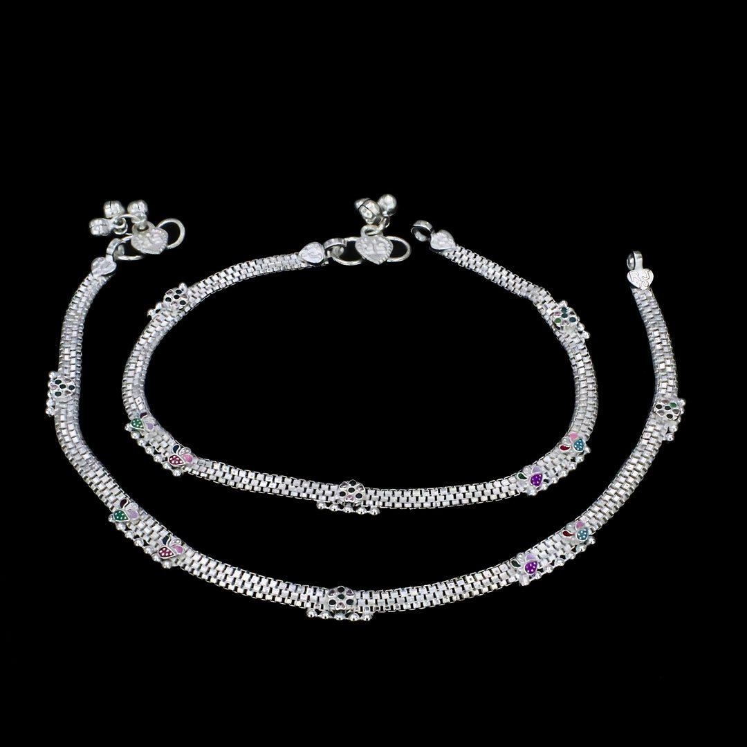 An overview of the image shows a pair of silver anklets displayed on a solid black background.